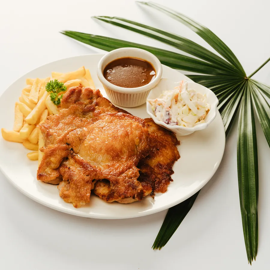 Signature chicken chop plated with fries, coleslaw and black pepper sauce